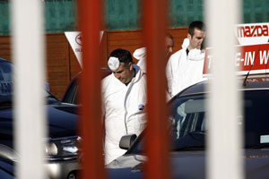Crime Scene Investigators examine the scene on the Greenhills Road