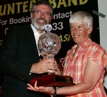 Gerry Adams makes a presentation of a piece of engraved crystal to Margaret McClenaghan