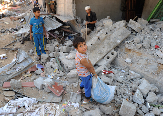 Palestine – Gaza Palestinians search through the rubble of their home destroyed by Israeli strikes in Khuza'a, southern Gaza Strip 2014