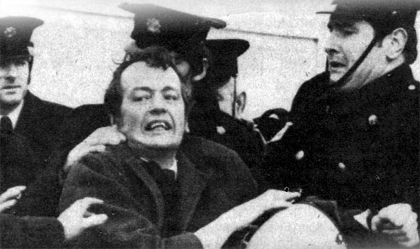 Seán Stagg, overcome with grief, is manhandled  by Gardaí at Shannon Airport as the remains of his brother are snatched