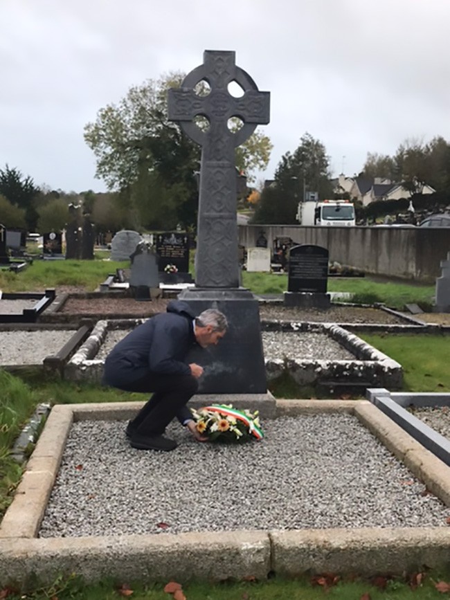 Cllr. Seán Conlon laying a wreath at the memorial to Vol. Michael Kelly in Latlurcan cemetery. Members of the Kelly family attended