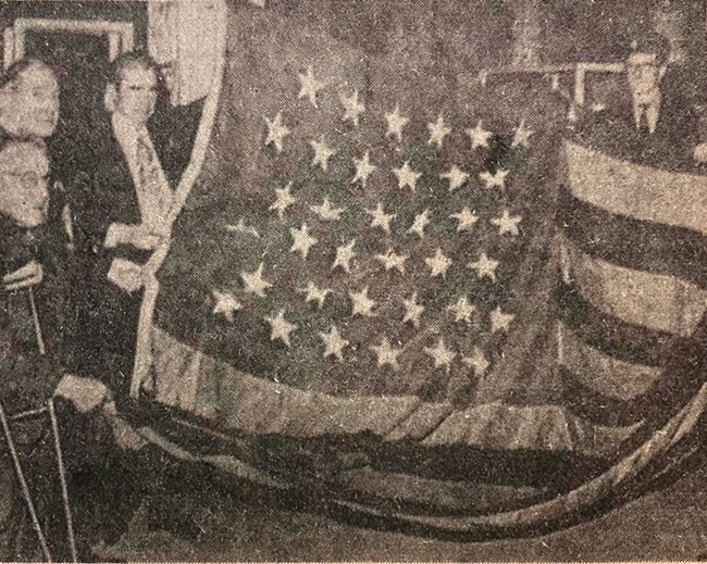 • Joe Clarke (left, on crutch) presenting the Catalpa flag to the National Museum in October 1972
