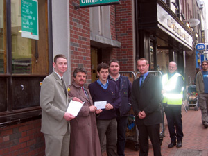 Local election candidate Tom Cunningham, Arthur Morgan TD and EU candidate John Dwyer hand a letter to postal worker Fiachra Mac Raghnaill in Drogheda