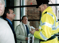 Councillor Michael Ferguson and Michael Power, whose son was gunned down by the UDA, are confronted by a PSNI member at the Ramada Hotel in Belfast