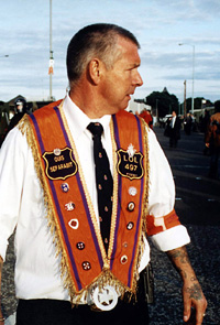 An Orange marcher in Ardoyne sports the UDA death squad's Quis Separabit slogan