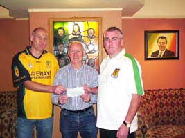 Paddy McCotter and Rab Kerr are presented with a cheques by Liam Shannon, chair of the Felon's Club, as a contribution to set up a GAA club in Twinbrook