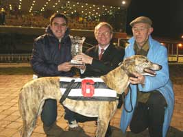 Martin McGuinness presents the winning trophy to Aidan Barry from Cloyne after Castlemary Socks won the feature race at the Sinn Féin benefit night in Curraheen Park. Also pictured: Bill O'Riordan