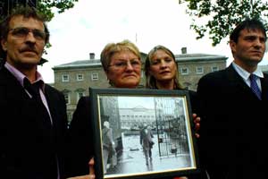 Dinah Fullerton and other family members outside Leinster House on Thursday carrying a photo of her husband leaving Leinster House in 1984