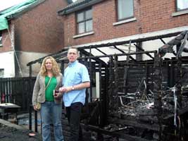 Tierna Cunningham and Gerry Kelly outside the child's playhouse gutted by loyalist arsonists