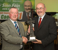 Cavan County Councillor Charlie Boylan presenting Caoimhghín Ó Caoláin TD with suitably inscribed Celtic Cross