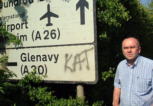 Paul Butler pictured beside sectarian graffiti which has been a regular feature of life in Stoneyford