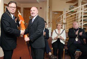 Alex Maskey presents Tom Hartley with the Tricolour