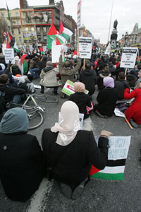 Protestors sit down on O’Connell Street Bridge during a rally in Dublin city centre over the Israeli Forces’ onslaught against Gaza