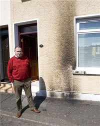 Mitchel outside his scorch damaged home, this was the third attack on his home in the past month